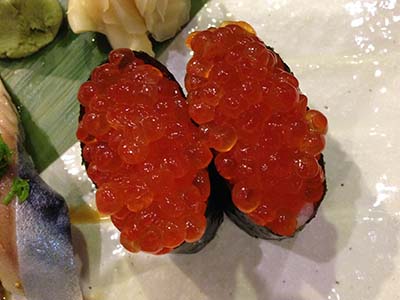 A sushi roll of nori wrapped into a cylinder and filled with salmon roe (ikura).