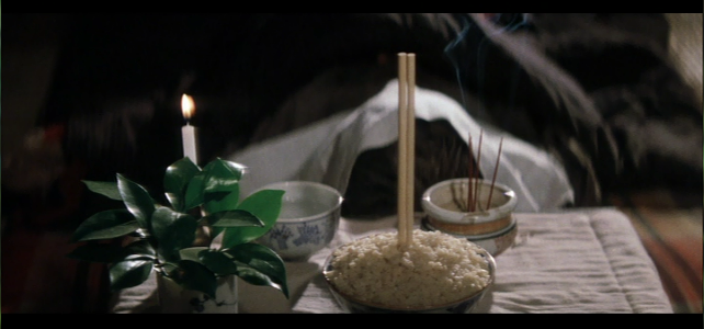 Bowl of rice at a grave with chop sticks