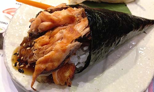 A cone of nori wrapped around grilled salmon skin.