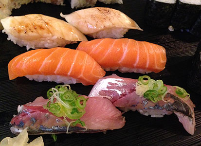 Three groups of nigiri sushi with white, red and silver colors of fish.
